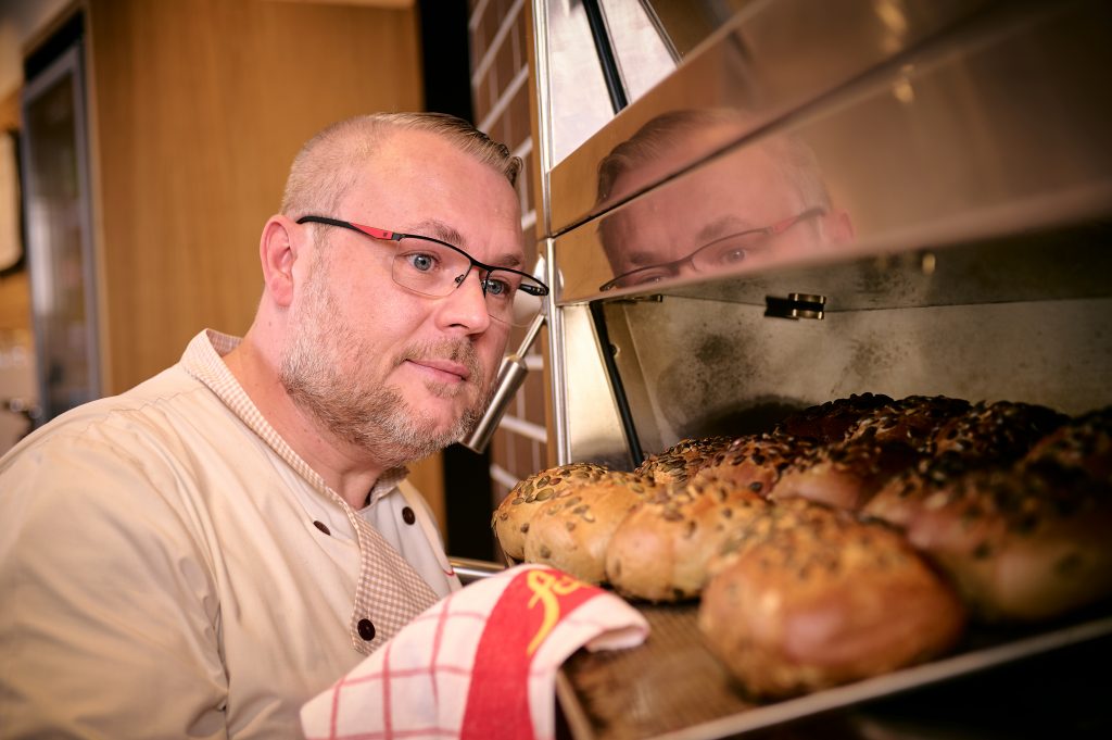 Verkäufer mit ofenfrischen Brötchen