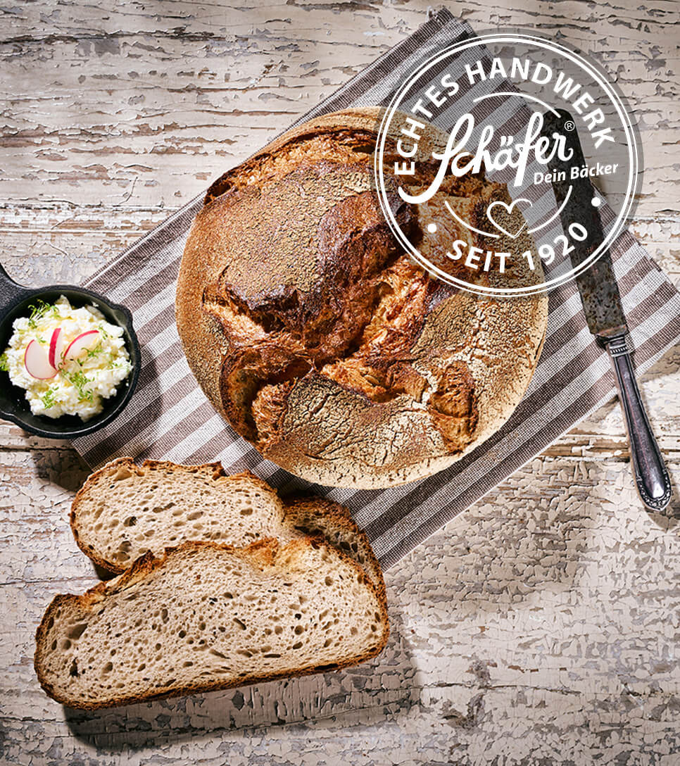 Schäfers Landbrot mit rustikaler Kruste, Brotscheiben auf Holzbrett